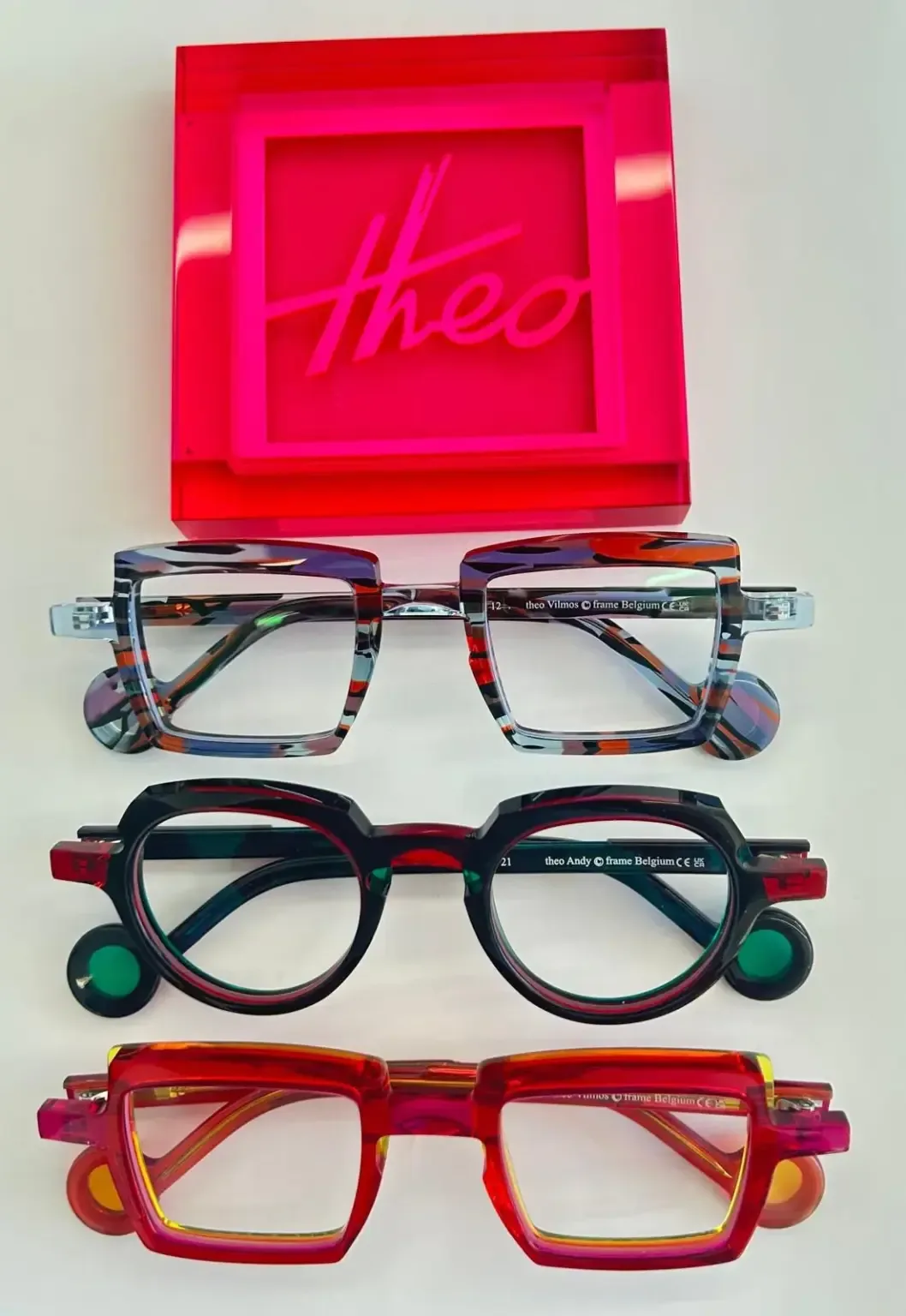 Theo statement glasses displayed beneath a pink Theo sign